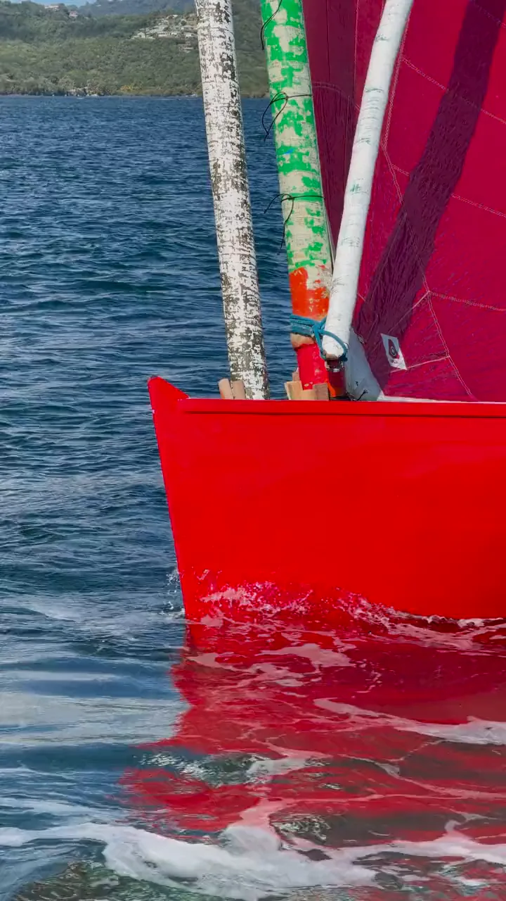 L’étrave rouge d’une yole ronde dans l’eau